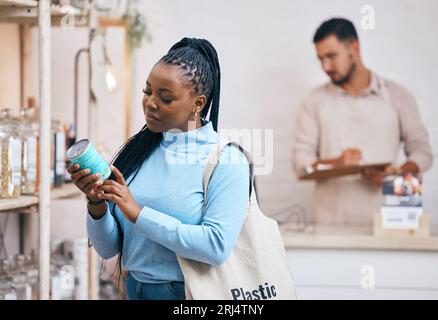 Einkaufen, Supermarkt und schwarze Frau am Regal für Auswahl, Optionen und Service in einem umweltfreundlichen Supermarkt. Kleine Unternehmen, Bioladen und Stockfoto