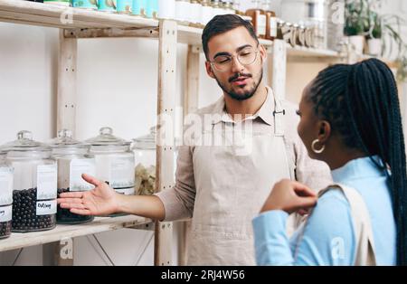 Supermarkt, Supermarkt und Manager mit Frau für Hilfe, Hilfe und Service in einem umweltfreundlichen Markt. Kleines Unternehmen, Bioladen und Mann mit Stockfoto