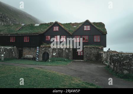 Eine wunderschöne Landschaft der Färöer Inseln mit malerischen, historischen Gebäuden im kleinen Dorf Kirkjubour Stockfoto