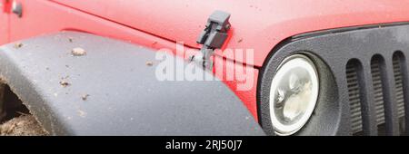 Rotes suv-Fahrzeug mit Schlamm auf Rädern aus nächster Nähe. Stockfoto