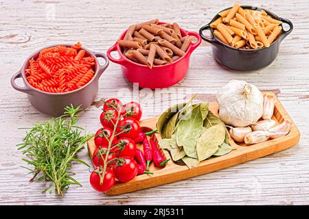 Ein Holztablett gefüllt mit einer Vielzahl von frischen Zutaten, die in der italienischen Küche verwendet werden, Pasta, Cherr Stockfoto