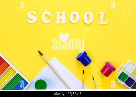 Farbenfrohe Schulsachen auf gelbem Hintergrund, Konzept „zurück zur Schule“, Draufsicht. Stockfoto