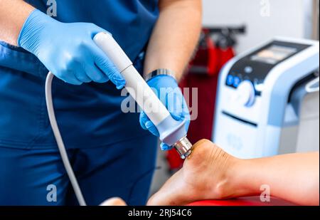 Physikalische Therapie des Fusses mit akustischen Stosswellen, Nahaufnahme. Stockfoto