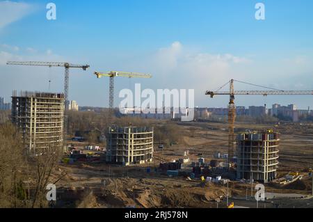 Draufsicht auf eine große Baustelle mit Kranen und Gebäuden mit monolithischen Rahmenelementen aus Beton, mehrstöckige Wolkenkratzer der großen Stadt Stockfoto