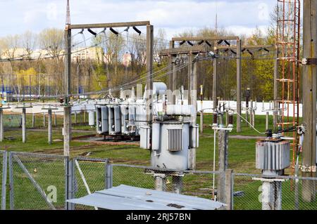 Große Umspannstation für industrielle Eisenmetalltransformatoren mit Transformatoren und Hochspannungselektrik sowie Drähten mit Überspannungsableitern zur Versorgung der Anlage Stockfoto