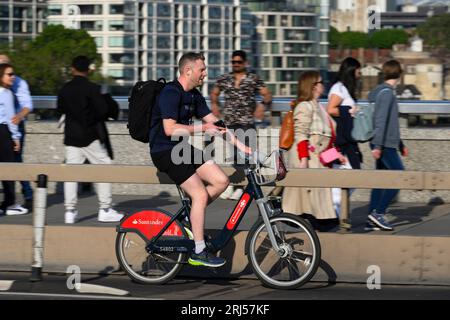 Ein Mann, der über die London Bridge radelt, auf einem Transport for London Santander Cycles mietet ein Fahrrad, das gemeinhin als „Boris Bike“ bekannt ist. London Bridge, London Stockfoto