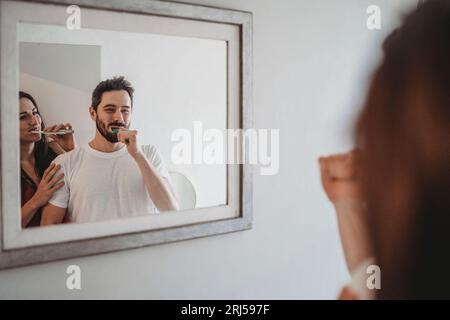 Ein paar junge Leute, die im Bad die Zähne putzen Stockfoto