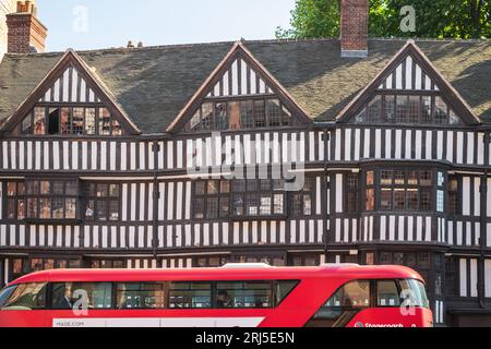 Ein ikonischer Londoner Bus, der an einem Tudor-Gebäude vorbeifährt, Staple Inn auf der Südseite der High Holborn Street Stockfoto