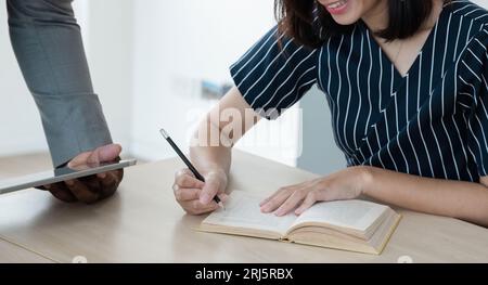 Bildung. Nahaufnahme eines jungen afro-amerikanischen Lehrers und einer asiatischen Schülerin während des Englischunterrichts. E-Learning Stockfoto