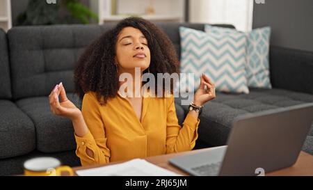 afroamerikanische Frau, die zu Hause Yoga-Übungen macht, hält an, um sich zu entspannen Stockfoto