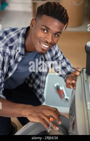 Ein Techniker repariert eine Waschmaschine Stockfoto