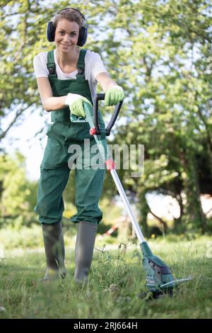 Junge Frau mäht das Gras Stockfoto