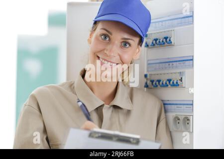 Glückliche Frau, die auf dem Klemmbrett schreibt Stockfoto
