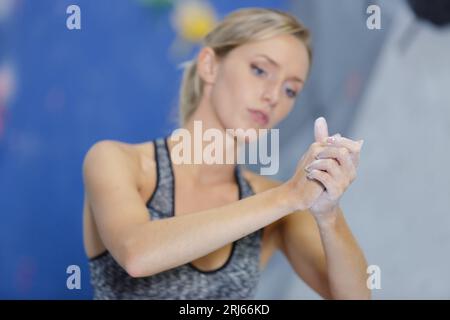 Frau, die vor dem Klettern Kreide auf ihre Hände aufträgt Stockfoto