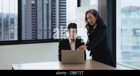 Planung eines Projekts im Büro. Technologie, Teamarbeit Zusammenarbeit Senior Manager erklärt einem Praktikanten für digitale Schulungen Stockfoto