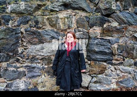 Eine Person, die gegen eine Steinmauer steht Stockfoto