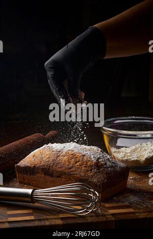 Eine Nahaufnahme eines Brotlaibs, der mit Mehl bestäubt wird. Stockfoto