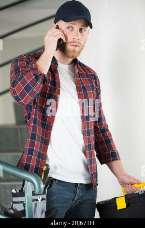 Junger Arbeiter am Telefon Stockfoto