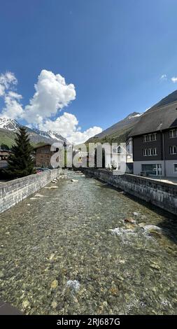 Eine malerische Szene eines Flusses, umgeben von Wohngebäuden. Andermatt, Schweiz. Stockfoto