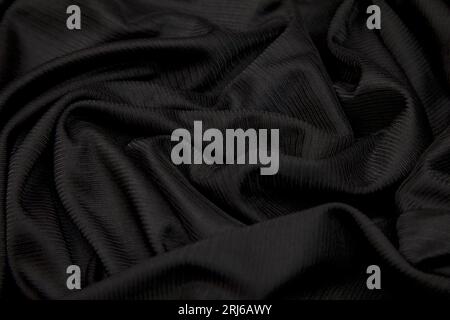 Ein klarer, schwarzer Stoffhintergrund mit hohem Kontrast sorgt für eine saubere, leere Leinwand für kreative Designs Stockfoto