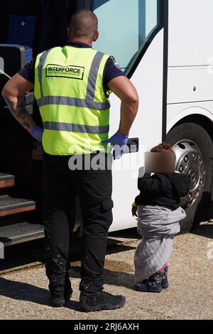 Das Gesicht von Child wurde verpixelt, da der PA Picture Desk nicht die erforderliche Erlaubnis erhalten hat, ein Kind unter 16 Jahren in Fragen ihres Wohlergehens zu fotografieren. Eine Gruppe von Menschen, die als Migranten gelten, wird nach Dungeness, Kent, gebracht. mit RNLI Rettungsboot nach einem kleinen Bootzwischenfall im Kanal. Bilddatum: Montag, 21. August 2023. Stockfoto