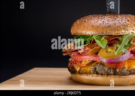 Ein großes, frisch zubereitetes Käseburger mit Salat und Zwiebeln aus nächster Nähe Stockfoto