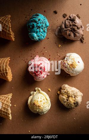 Eine lebhafte und farbenfrohe Auswahl an Eis, frischem Obst und verschiedenen köstlichen Belägen auf einer weißen Tischplatte Stockfoto