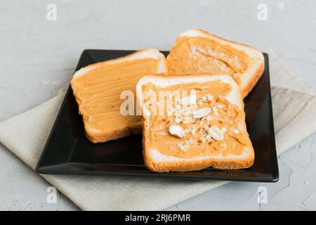 Erdnussbutter-Sandwiches oder Toast auf hellem Tischhintergrund. Frühstück. Vegetarisches Essen. Amerikanische Küche, Top-View mit Kopierbereich. Stockfoto