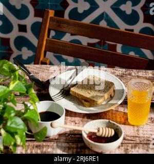 Ein rustikaler Holztisch für ein gemütliches Frühstück mit zwei Scheiben geröstetem Brot und aromatischem Kaffee Stockfoto