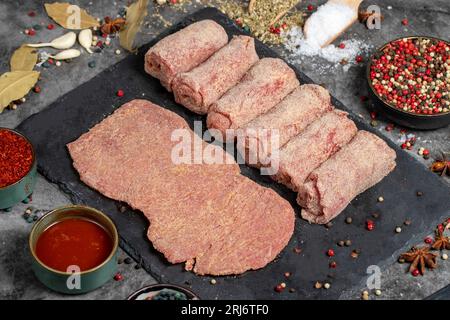 Fleischschnitzel. Rohes Rindfleisch-Schnitzel auf dunklem Hintergrund. Metzgerprodukte Stockfoto