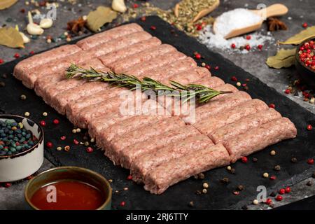 Rohes Rindfleisch. Frische rohe Rindfleischbällchen auf dunklem Hintergrund. Metzgerprodukte. Lokaler Name inegol kofte Stockfoto