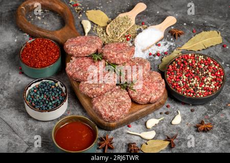 Rohes Rindfleisch. Frische rohe Rindfleischbällchen auf dunklem Hintergrund. Metzgerprodukte Stockfoto