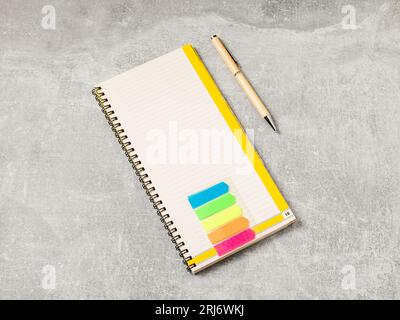 Bürowerkzeuge. Notizblock und Stift auf grauem Bürotisch.flache Verlegung Stockfoto
