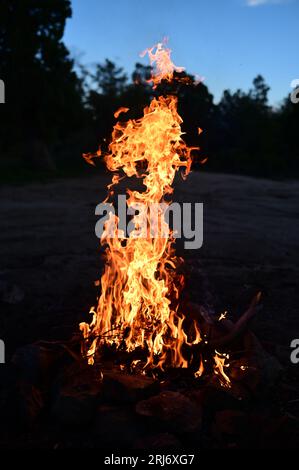 Eine faszinierende Szene, in der ein intensives Feuer hell vor einem Nachthimmel brennt und Rauch aus den Flammen steigt Stockfoto