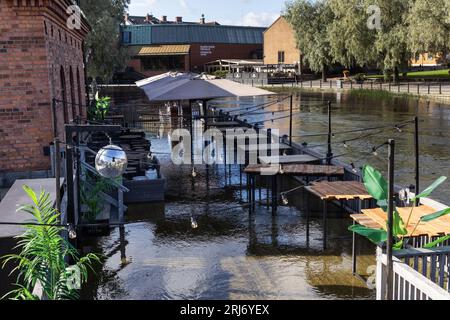 Überflutete Faluån (Fluss) im Zentrum von Falun, Schweden. Auf dem Bild: Wasser in einem Restaurant im Freien neben dem Fluss. Stockfoto