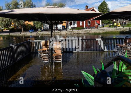 Überflutete Faluån (Fluss) im Zentrum von Falun, Schweden. Auf dem Bild: Wasser in einem Restaurant im Freien neben dem Fluss. Stockfoto