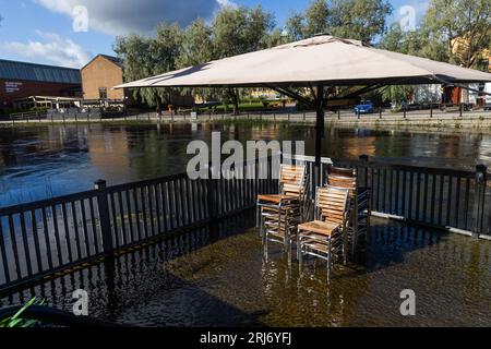 Überflutete Faluån (Fluss) im Zentrum von Falun, Schweden. Auf dem Bild: Wasser in einem Restaurant im Freien neben dem Fluss. Stockfoto