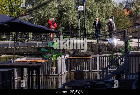 Überflutete Faluån (Fluss) im Zentrum von Falun, Schweden. Auf dem Bild: Wasser in einem Restaurant im Freien neben dem Fluss. Stockfoto