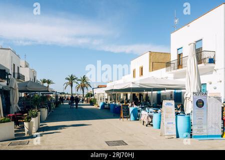 Eine Straße mit Restaurants im touristischen San Vito lo Capo vor einem blauen Himmel. Stockfoto