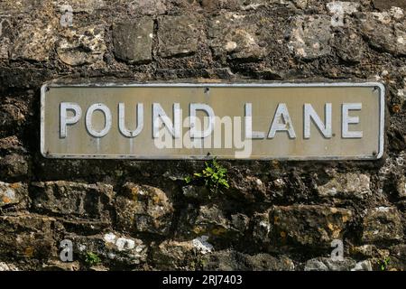 Sreet-Schild für Pound Lane gegen eine Steinmauer. Caerwent Village, Südwales. August 2023 Stockfoto