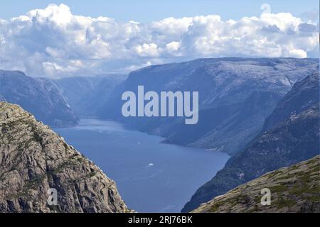 Begeben Sie sich auf ein unvergessliches norwegisches Abenteuer in der Nähe von Stavanger, wo hoch aufragende Berge auf dieser fesselnden Wanderung über einen gewundenen Fjord wachen. Stockfoto