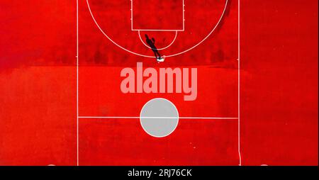 Rotes Minimal-Basketballfeld von oben gesehen. Stockfoto