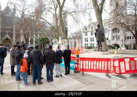 Die Menschen versammeln sich vor der Statue von Mahatma Gandhi auf dem Parliament Square im Zentrum von London. Stockfoto