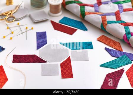 Die Herstellung von Stoffstücken für Quiltblöcke Nähen, Quiltfragment, Quilten und Nähzubehör auf weißem Hintergrund Stockfoto