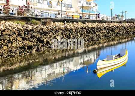 Cabanas de Tavira, Portugal - 20. Oktober 2022: Wunderschönes gelbes Kanu auf ruhigem blauem Wasser Stockfoto