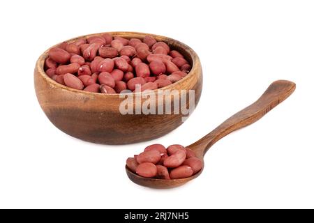 Holzschale und Löffel mit Erdnüssen auf weißem Hintergrund. Leerzeichen kopieren. Stockfoto