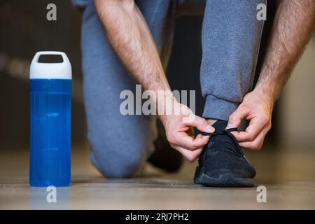 Sportler, der Schnürsenkel an Sportschuhen sichert Stockfoto