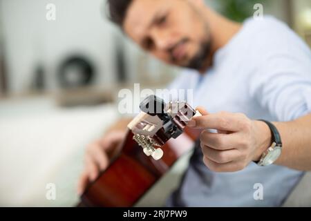 Junge gut aussehende Werkstatt Reparatur Gitarre Stockfoto