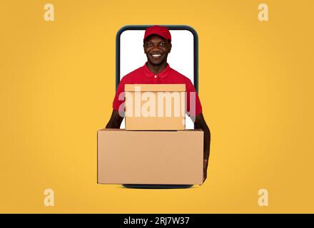 Der fröhliche, tausendjährige afroamerikanische Boy-Kurier in Uniform hält viele Boxen auf dem Großbildschirm-Smartphone Stockfoto
