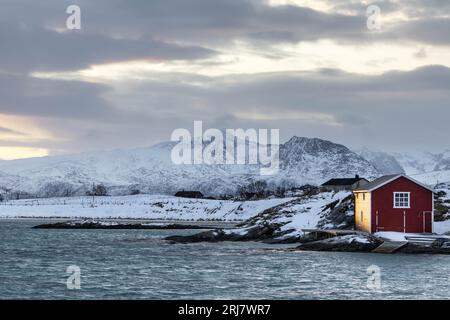 Traditionelles rotes Haus an der Küste von Sommaroy in Norwegen im Winter Stockfoto